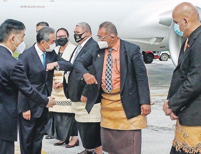 CHINA’S Foreign Minister Wang Yi, second left, is welcomed on the tarmac by officials on his arrival in Nuku’alofa, Tonga, on Tuesday. Photo: Marian Kupu/ABC via AP