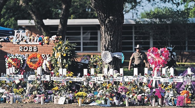 FLOWERS and candles are placed around crosses at a memorial outside Robb Elementary School to honour the victims killed in this week’s school shooting in Uvalde, Texas. Photo: Jae C Hong/AP