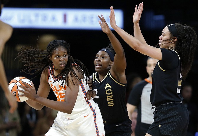 Connecticut Sun forward Jonquel Jones (35) is guarded by Las Vegas Aces guard Chelsea Gray (12) and forward Dearica Hamby, right, during a WNBA basketball game in Las Vegas on Thursday, June 2, 2022. (Steve Marcus/Las Vegas Sun via AP)