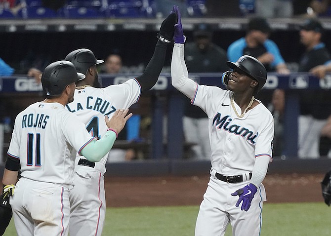 MIAMI Marlins’ Miguel Rojas (11) and Bryan De La Cruz (14) congratulate Jazz Chisholm Jr. after Chisholm hit a grand slam in the second inning against the Washington Nationals Tuesday. 
(AP Photos/Marta Lavandier)