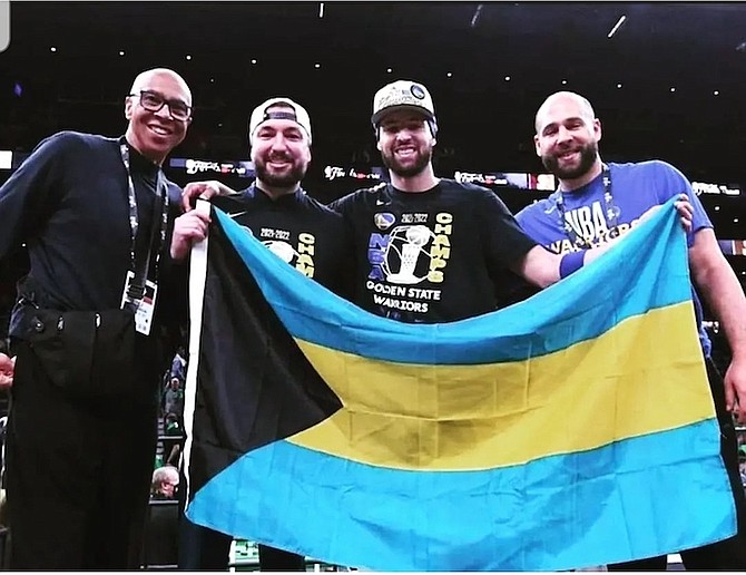 Klay Thompson poses with his father Mychal Thompson and brothers Trayce and Michael Thompson as they display the Bahamian flag.