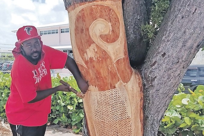 ARTIST Julian McKenzie carving tree trunk sculptures in downtown Freeport.
Photo: Denise Maycock/Tribune Staff