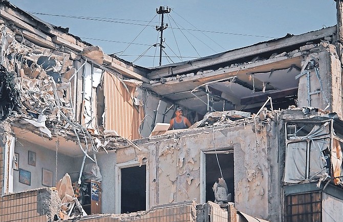 A MAN cleans an apartment destroyed after Russian shelling in Nikopol, Ukraine, Monday.
(AP Photo/Kostiantyn Liberov)