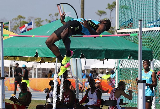 Donald Thomas clearing the bar in the men's high jump as Shaun Miller Jr looks on.