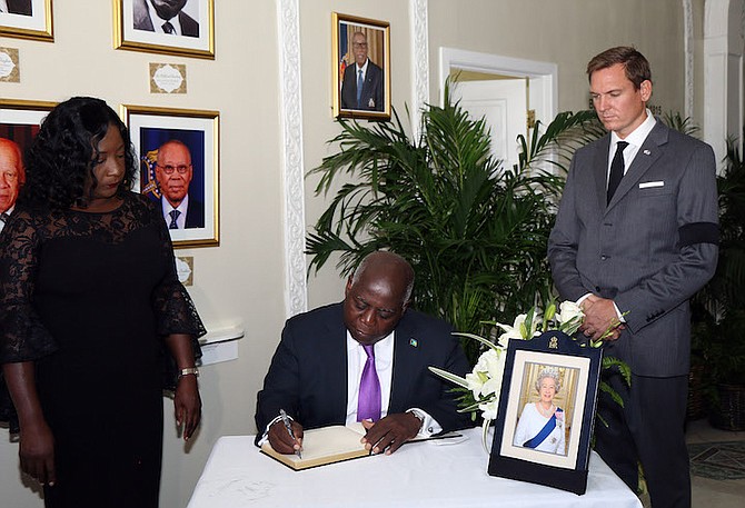 Prime Minister Philip ‘Brave’ Davis signs the Book of Condolence on the passing of Her Majesty Queen Elizabeth II at the Senate. Looking on are President of the Senate LaShell Adderley and British High Commissioner to the Commonwealth of The Bahamas Thomas Hartley.  (BIS Photo/Patrick Hanna)