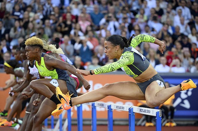 DITAJI KAMBUNDJI, right, of Switzerland, competes next to Devynne Charlton, left, of the Bahamas, in the 110m Hurdles during the Weltklasse IAAF Diamond League international athletics meeting at the Letzigrund stadium in Zurich, Switzerland, yesterday.
(Jean-Christophe Bott/Keystone via AP)