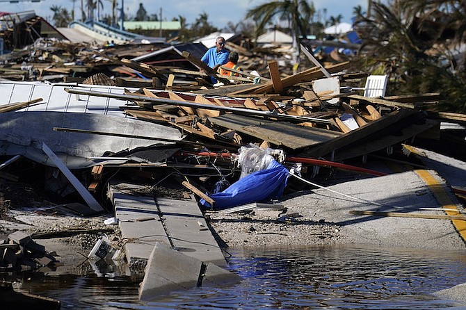 Responders from the de Moya Group survey damage to the bridge leading to Pine Island, to start building temporary access to the island in the aftermath of Hurricane Ian in Matlacha, Fla., Sunday. (AP Photo/Gerald Herbert)