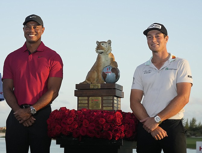 VIKTOR HOVLAND, right, poses for a photo with tournament host Tiger Woods, left, after he won the Hero World Challenge PGA Tour at the Albany Golf Club yesterday. 
(AP Photo/Fernando Llano)
