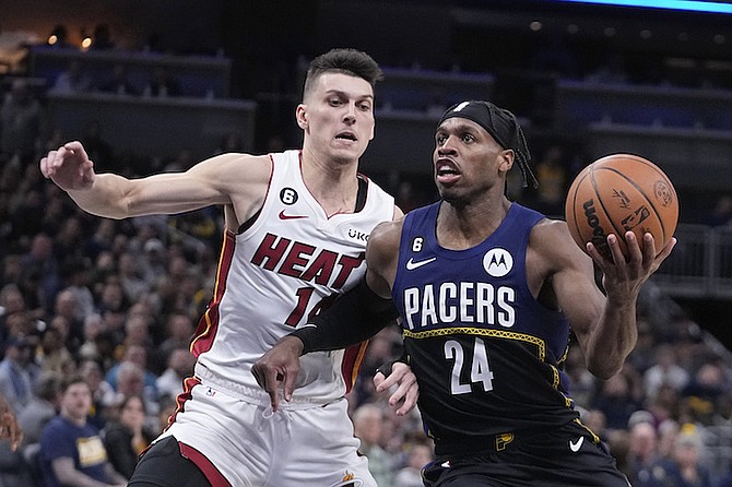 INDIANA Pacers’ Buddy Hield (24) goes to the basket against Miami Heat’s Tyler Herro (14) during the second half last night in Indianapolis.
(AP Photo/Darron Cummings)