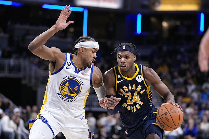 Indiana Pacers guard Buddy Hield (24) drives on Golden State Warriors guard Moses Moody (4) during the second half of an NBA basketball game in Indianapolis, Wednesday, Dec. 14, 2022. The Pacers defeated the Warriors 125-119. (AP Photo/Michael Conroy)