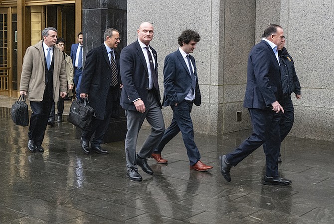 Cryptocurrency entrepreneur Sam Bankman-Fried, second from right, arrives for an appearance at Manhattan federal court Tuesday, in New York. Bankman-Fried will be arraigned in a Manhattan federal court Tuesday on charges that he cheated investors and looted customer deposits on his cryptocurrency trading platform. (AP Photo/Craig Ruttle)