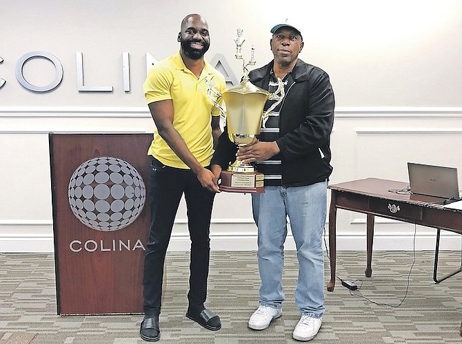 KENDRICK KNOWLES, president of the BCF, presents champion NM Valentino Cox with his huge trophy.