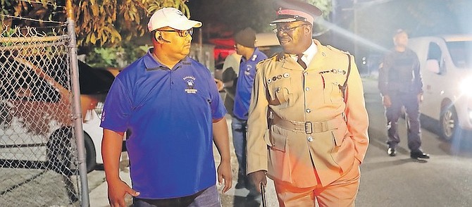 KENO WONG, of the National Neighbourhood Watch Council, alongside officer in charge of community policing Darvy Pratt last night. The two joined a team of police visiting hotspots in New Providence as part of a project involving Bahamas Power & Light to improve lighting in areas where violence has been more common. Photos: Austin Fernander