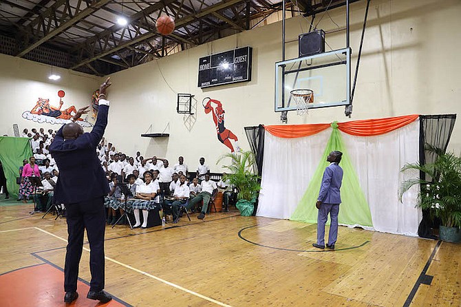 LET THE GAMES BEGIN - Minister of Youth, Sports and Culture Mario Bowleg shoots a basketball yesterday to signify the official opening of the prestigious Hugh Campbell Basketball Classic for senior boys. The opening ceremonies were held at AF Adderley Gymnasium but the games will be played at the Kendal Isaacs Gym. 
Photo: Austin Fernander/Tribune Staff