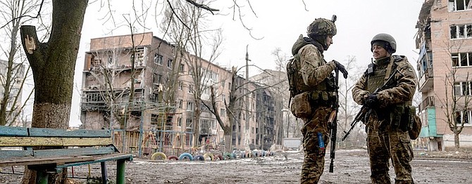 UKRAINIAN marine servicemen stand on a street in front of the residential building which was heavily bombed by Russian forces, in the frontline city of Vuhledar, Ukraine, on Saturday. 
Photo: Evgeniy Maloletka/AP