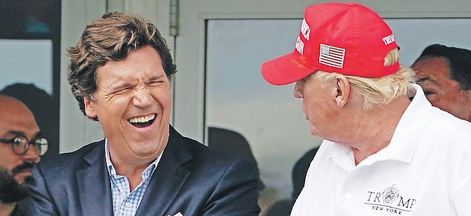 TUCKER CARLSON, left, and former President Donald Trump, right, react during the final round of the Bedminster Invitational LIV Golf tournament in Bedminster, New Jersey, July 31, 2022. A defamation lawsuit against Fox News is revealing blunt behind-the-scenes opinions by its top figures about Donald Trump, including a Tucker Carlson text message where he said “I hate him passionately.” 
Photo: Seth Wenig/AP