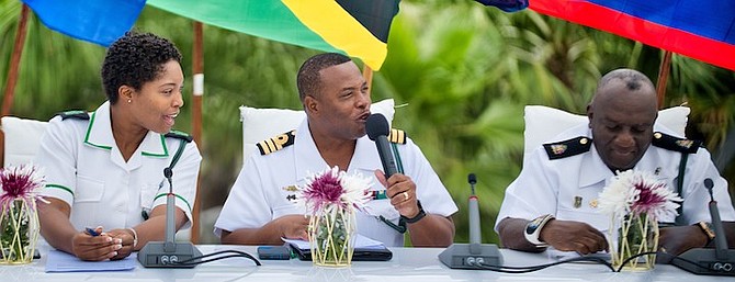 COMMANDER Origin Deleveaux makes some remarks as he is flanked by Petty Officer Shantell Brennen and Chief Petty Officer John Ingraham.