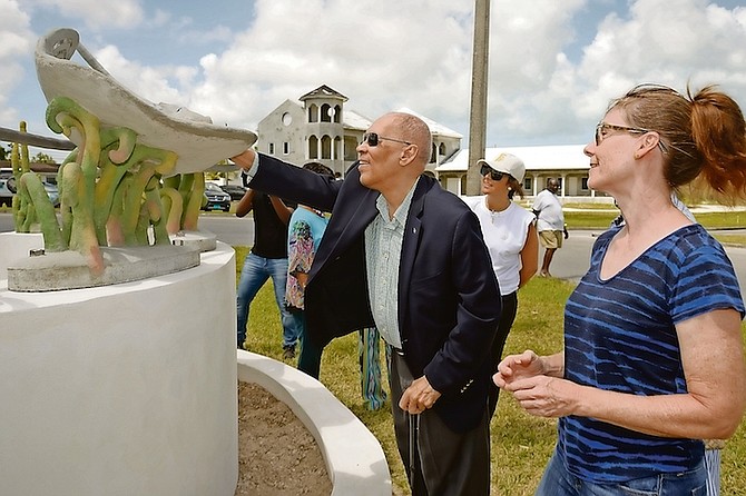 FORMER Governor General Sir Arthur Foulkes examining the stingray sculpture.