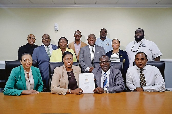 PUBLIC Service Minister Pia Glover-Rolle, union president Kimsley Ferguson and Parliamentary Secretary in the Ministry of Public Service Gina Thompson with others at the signing yesterday.
Photos: Austin Fernander