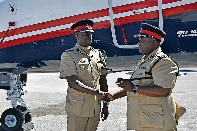 ACP Theophilus Cunningham shakes hands with Assistant Commissioner of Police B K Bonamy Jr, as he prepares to depart Grand Bahama on Thursday after completing his tenure and turning over command of the Grand Bahama and northern Bahamas District to ACP Bonamy.