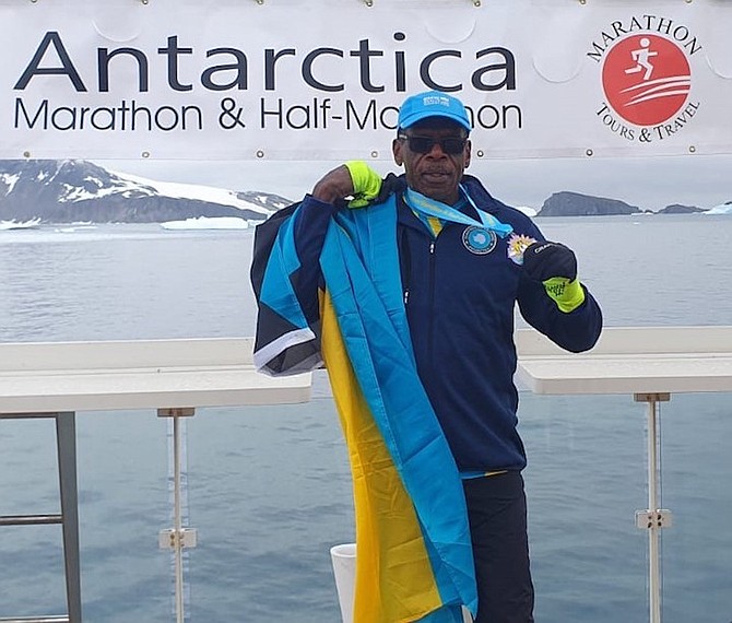 Charles Johnson with the Bahamian flag and his medal.