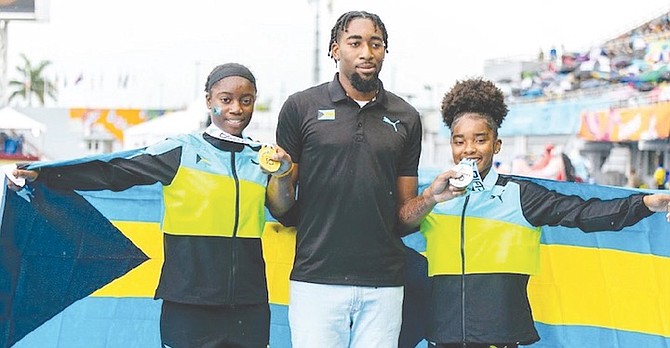 National javelin record holder Keyshawn Strachan presents gold and silver medals to his sister Kamera Strachan and Dior-Ray Scott respectively.