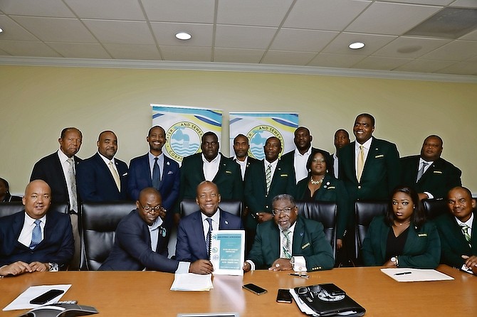 Minister of Works Alfred Sears (center) holds a copy of the $3m industrial agreement along with Dwayne Woods (right), president of the Bahamas Utility and Allied Workers union, which was signed between the union and Water and Sewerage Corporation yesterday.
Photo: Austin Fernander