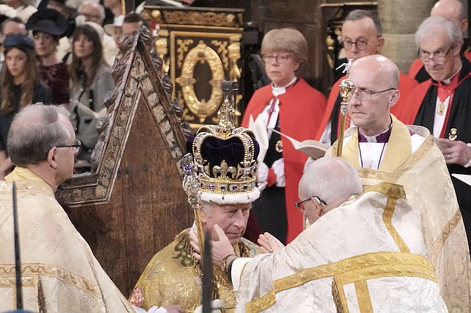 King Charles III sits as he is crowned with St Edward's Crown by The Archbishop of Canterbury the Most Reverend Justin Welby during the coronation ceremony at Westminster Abbey, London, Saturday. (Jonathan Brady/Pool Photo via AP)
