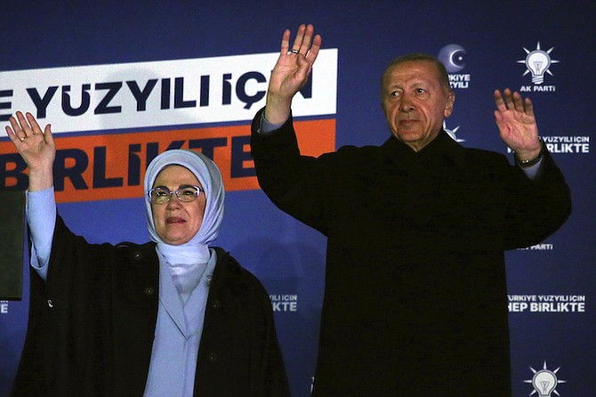 Turkish President Recep Tayyip Erdogan, right, and his wife Emine gesture to supporters at the party headquarters, in Ankara, Turkey, early Monday. Erdogan, who has ruled his country with an increasingly firm grip for 20 years, was locked in a tight election race Sunday, with a make-or-break runoff against his chief challenger possible as the final votes were counted. 
Photo: Ali Unal/AP
