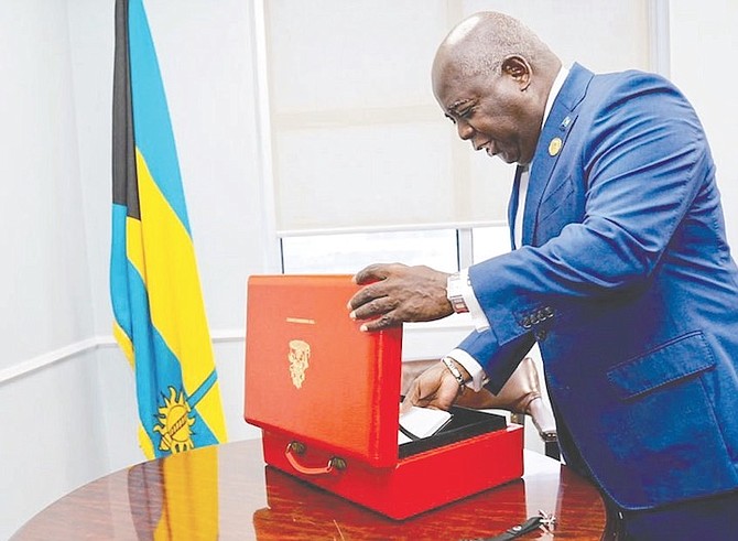 Prime Minister Philip ‘Brave’ Davis places the budget communication in the traditional red briefcase yesterday, before heading to the House of Assembly.
Photo: BIS