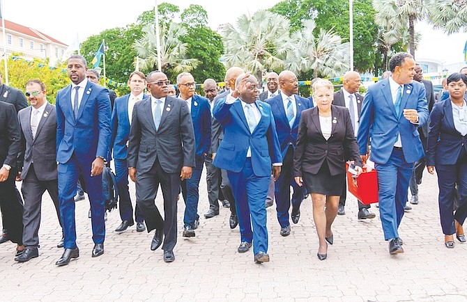 Philip ‘Brave’ Davis and PLP MPs yesterday head to the opening budget communication with the red briefcase containing the budget document carried by Minister of Economic Affairs Michael Halkitis.
Photo: Moise Amisial