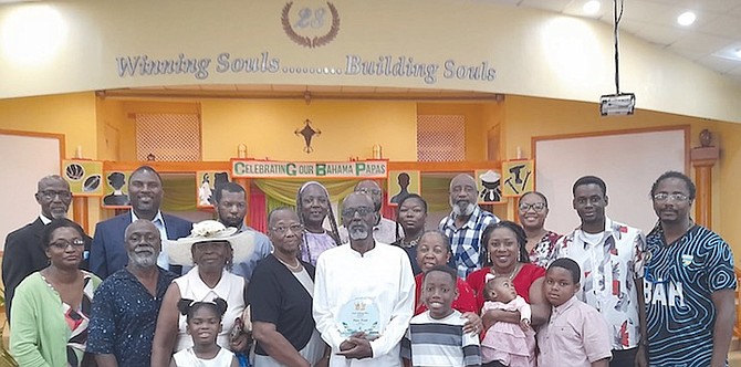FORMER triple jumper turned coach Peter Pratt (white shirt) is flanked by family members, friends and members of the Bahamas Association of Athletic Associations (BAAA), including president, Drumeco Archer. Pratt was presented with a plaque at Christ Community Church with the “First Among Men’’ award.