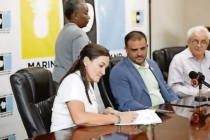 Agriculture Minister Clay Sweeting looks on as vice president of BAARK, Lisa McCombe, (left) signs a MOU with the Ministry of Agriculture to create the Nassau Animal Sanctuary.
Photo: Moise Amisial