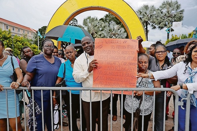 BPSU president Kimsley Ferguson (holding poster), who represents social services and healthcare workers, yesterday during a protest in Rawson Square, accused the government of taking advantage of public servants. 
Photo: Austin Fernander
