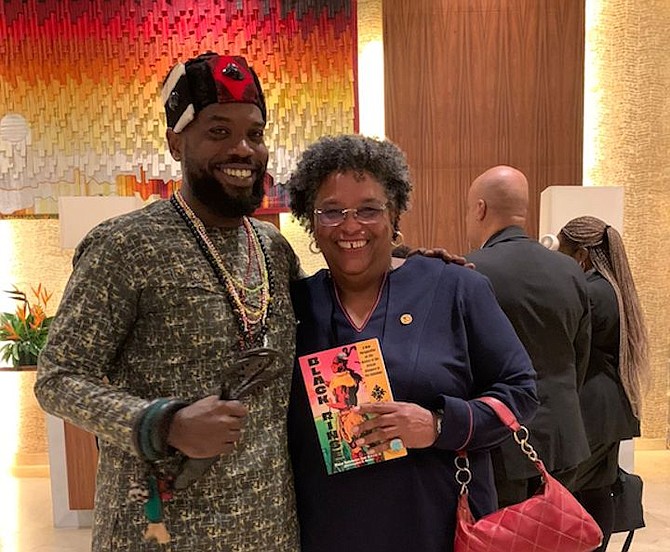 Christopher Davis presents an autographed copy of his book Black Rinse to Barbados' Prime Minister Mia Mottley while in Ghana.