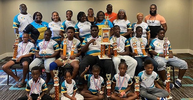 Bahamas Centre For Martial Arts athletes and coaches display their medals and trophies won at the US Open Martial Arts Championship.