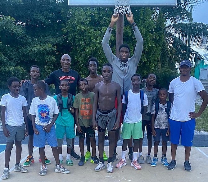 LEGENDARY Olympic bronze medallist Frank Rutherford and Winslow Barry Jr, pulling the nets, pose with campers during the Mega Malt basketball camp.