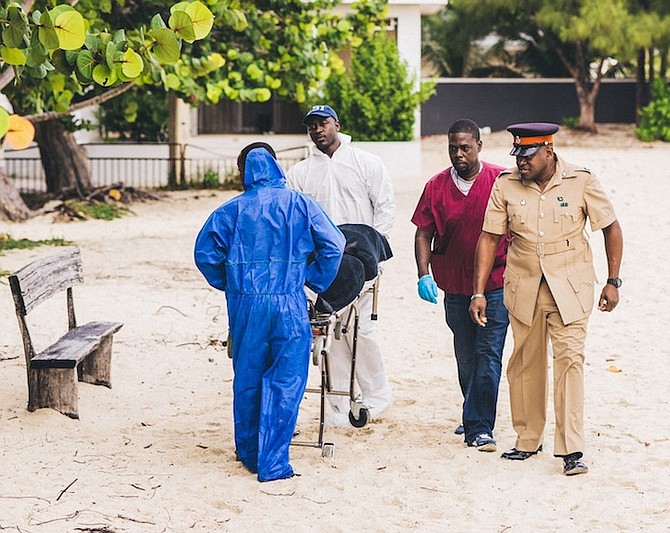 The body is removed from Saunders Beach on Monday morning. Photos: Moise Amisial