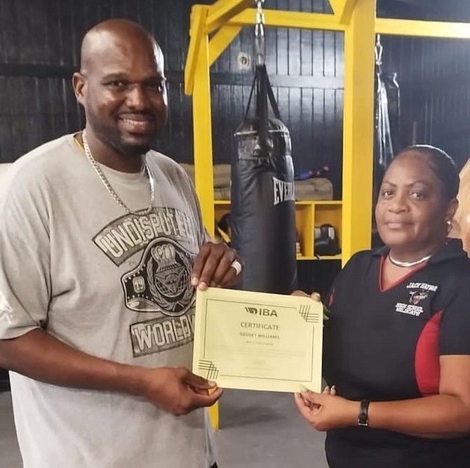 Grand Bahama Amateur Boxing Association president Jermaine Gibson presents Geddet Williams with her certified coaching certificate.
