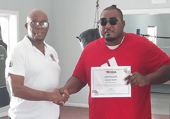 President Vincent Strachan presents coaching certification to Keishno Major.
