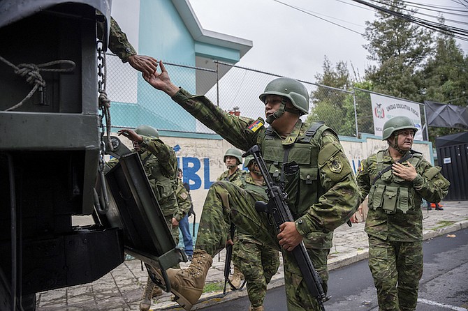 SOLDIERS board a truck after reinforcing security at the polling station where presidential candidate Christian Zurita, for “Movimiento Construye,” voted in a snap election in Quito, Ecuador, last Sunday. Zurita’s name was not on the ballot, but he substituted Villavicencio who was killed while at a campaign rally. (AP Photo/Carlos Noriega)