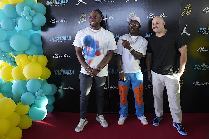 Miami Marlins' Jazz Chisholm Jr., centre, poses for photos with teammates Josh Bell, left, and Jake Burger at the launch party for the Jazz Chisholm Foundation, Monday, in Miami.