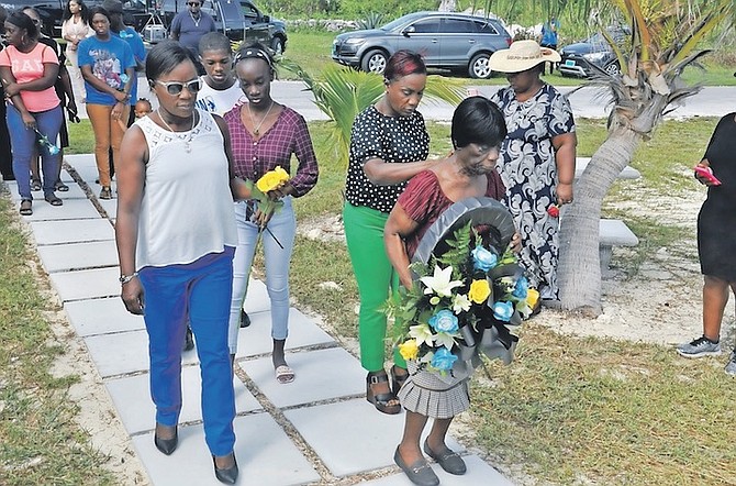ODETTA COOPER, accompanied by her twin daughters and grandchildren, carries a wreath to lay at the memorial monument at High Rock in memory of her children, Aaron, Adam and Daniel Cooper. Photos: Vandyke Hepburn