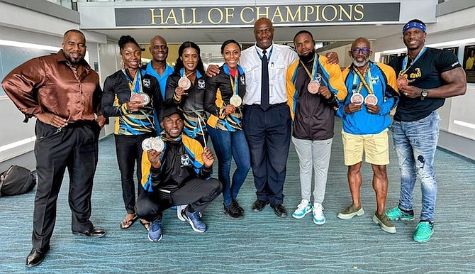 Federation president Joel Stubbs, wearing tie, poses with Team Bahamas on their return home.