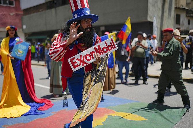 A MAN dressed as the US character Uncle Sam holds an Exxon oil company sign during a progovernment march coined “Take back the Esequibo,” the name of a territory under dispute between Venezuela and Guyana, in Caracas, Venezuela, Tuesday, last week.
Photo: Ariana Cubillos/AP