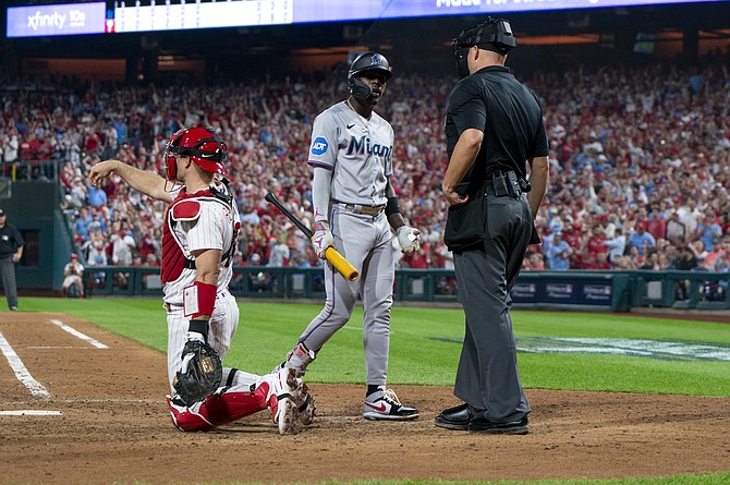Jasrado Chisholm Jr, centre, reacts to being called out on strikes by umpire Stu Scheurwater, right, during Game 1 of the NL wild-card baseball playoff series Tuesday. 
(AP Photo/Chris Szagola)