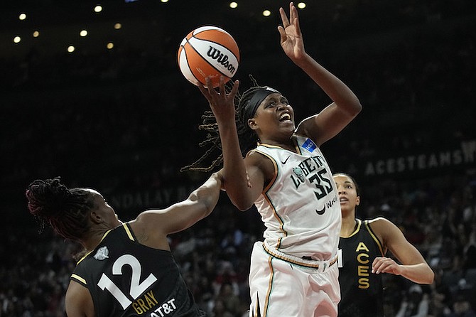 Las Vegas Aces guard Chelsea Gray (12) fouls New York Liberty forward Jonquel Jones during the first half in Game 2 of a WNBA basketball final playoff series on Wednesday, October 11, 2023, in Las Vegas. 

(AP Photo/John Locher)