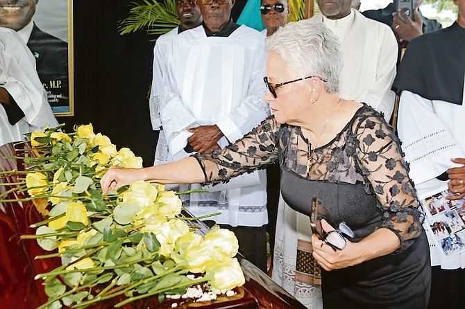 Minister of Education Glenys Hanna Martin lays a rose on the casket of Obie Wilchcombe as colleagues, family and friends bid a last farewell at the graveyard in West End, Grand Bahama on Saturday.
Photo: Vandyke Hepburn