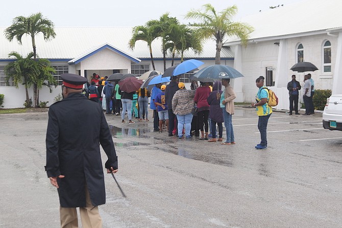PEOPLE wait in line in the rain to vote in the West Grand Bahama and Bimini by-election.
Photo: Vandyke Hepburn