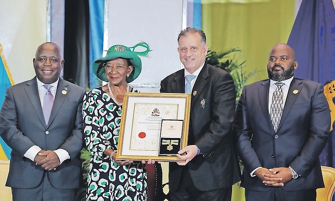 Tribune president Robert Carron receives a Golden Jubilee award on behalf of Tribune publisher Eileen Dupuch Carron yesterday from Deputy Governor General Ruby Ann Darling, flanked by Prime Minister Philip “Brave” Davis and Chief Justice Ian Winder.
Photo: Dante Carrer